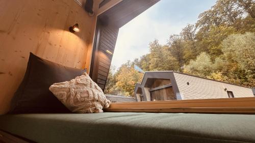 een kussen op een bed in een kamer met een raam bij elsPARC Walkenried in Zorge