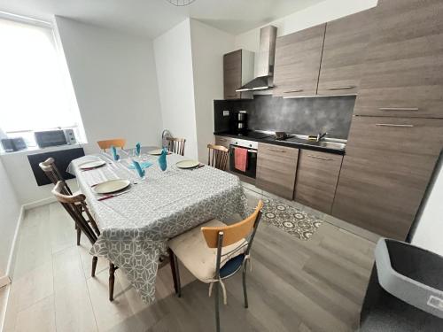 Saint-Julien-lès-MetzにあるAppartement 5 lits Wifi Un Séjour à Partのダイニングルーム(テーブル、椅子付)、キッチン