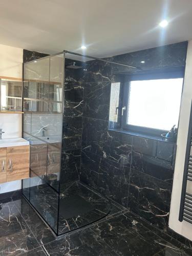 Un baño con ducha de cristal y lavabo. en Hébergement curgy, en Curgy