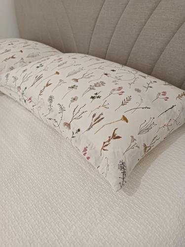 a pillow with a floral pattern on a bed at Il sogno apartman in Vranješ