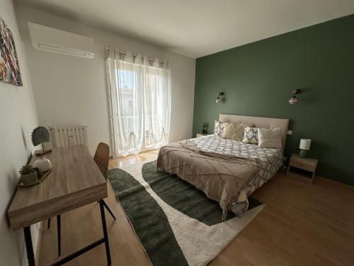 a green bedroom with a bed and a table at Villa Mars YourHostHelper in Narbonne