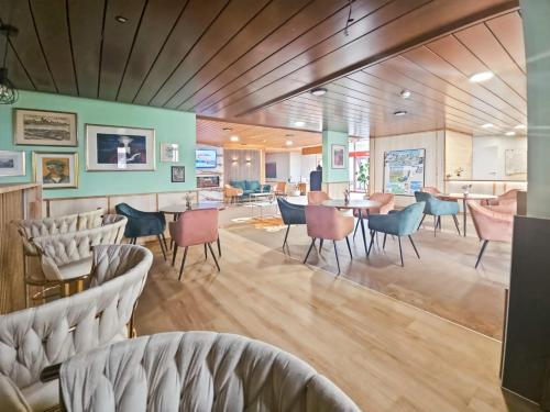 a restaurant with chairs and tables in a room at Hotel Aeschi Park in Aeschi