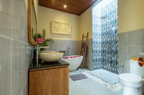 un bagno con vasca, lavandino e WC di Rama Ubud Villa ad Ubud