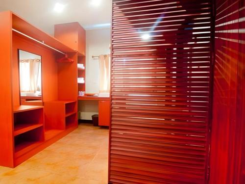 a room with orange walls and a wooden wall at Kwan Phayao Villa in Phayao