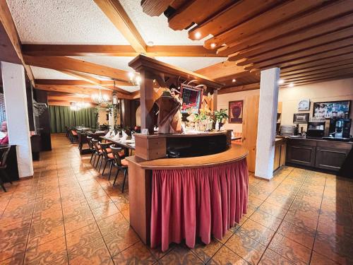 un restaurante con un bar con mesa y sillas en Gasthof Söll, 