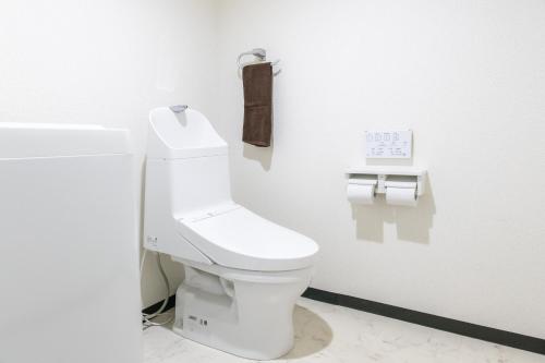 ein Badezimmer mit einer weißen Toilette in einem Zimmer in der Unterkunft Hotel Small World in Hiroshima