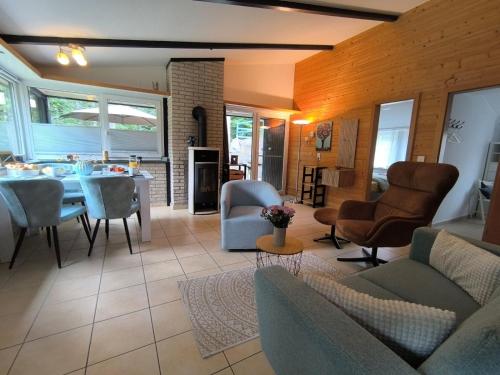 a living room with a couch and a table and chairs at Ferienhaus "WaldLust" - Waldrandlage - Haustierfreundlich in Gerolstein