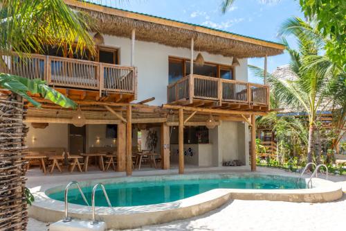 a villa with a swimming pool and a house at MAKU Oasis Villas and Studios in Makunduchi