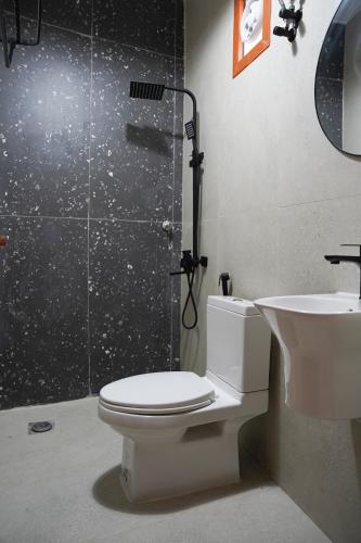 a bathroom with a toilet and a shower and a sink at Misfah Ambah house in Misfāh