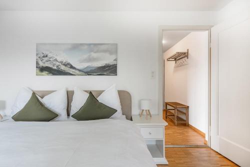 Dormitorio blanco con cama blanca y almohadas verdes en SOHO3A !Gratis Parken, Free Parking!, en Kreuzlingen