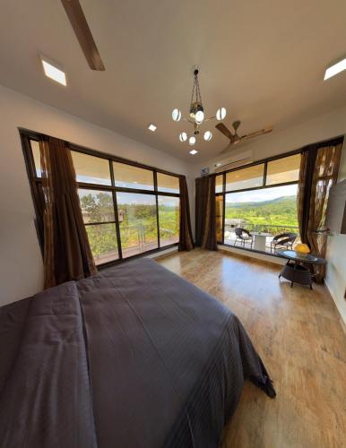 Un dormitorio con una cama grande y grandes ventanales. en Estillo -River touch, Mountain view, en Mundhwa