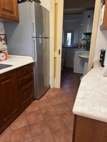 een keuken met een koelkast en een tegelvloer bij Casa Genovesi 5 in Salerno