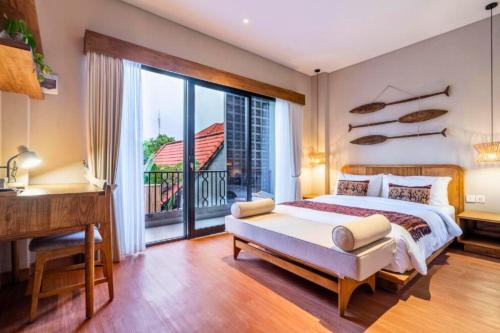 a bedroom with a bed and a desk and a window at Esmeralda1 BR Shared Pool ZN284 in Pererenan