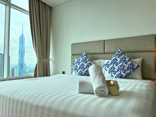 a bedroom with a large bed with blue and white pillows at Vortex Apartments Kuala Lumpur in Kuala Lumpur