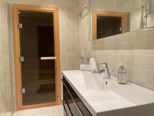 a white bathroom with a sink and a mirror at Moderne storhytte med 5 soverom og 3 bad in Beitostøl