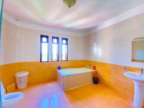 a bathroom with a tub and a sink and a toilet at Shabiki Sea View Apartments in Mombasa