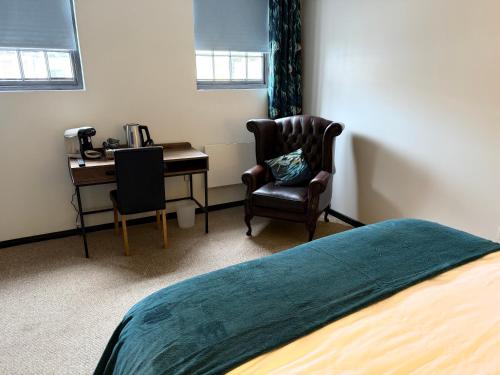 a bedroom with a desk and a bed and a chair at The Wheatsheaf in Tempsford 