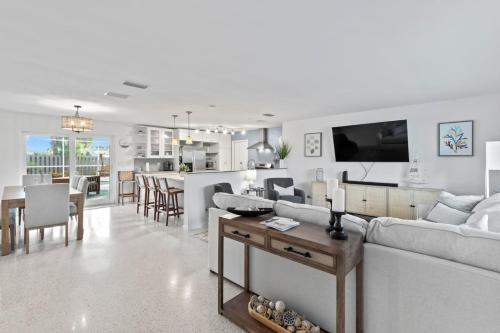 Una sala de estar y una cocina con un sofá y una mesa. en Sandcastle Harbor Pool & FirePit Steps to the Beach, en Wilbur-by-the-Sea
