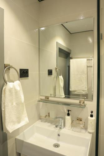 タシュケントにあるDoo Hostel Tashkent cityの洗面台と鏡のある白いバスルーム
