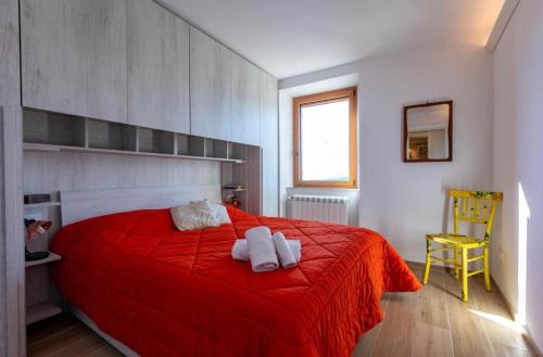 サンタ・フィオーラにあるCASA DELLA VOLPA - Tuscan ToBe srlのベッドルーム1室(赤いベッド1台、タオル2枚付)