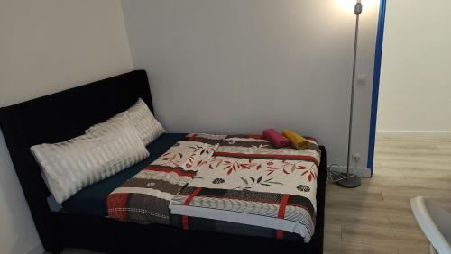 a small bedroom with a bed with a blanket at 1 chambre meublé avec cuisine privé métro 7 la Courneuve in La Courneuve