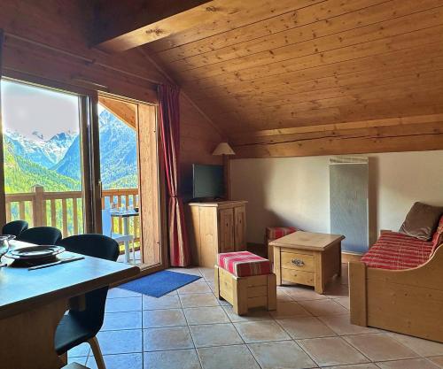 a room with a table and chairs and a large window at Mira, Vue Exceptionnelle confort piscine, Spa in Champagny-en-Vanoise
