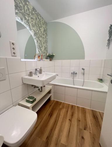 a bathroom with a sink and a tub and a toilet at Dimoro Family Suites - Designed for your comfort in Essen