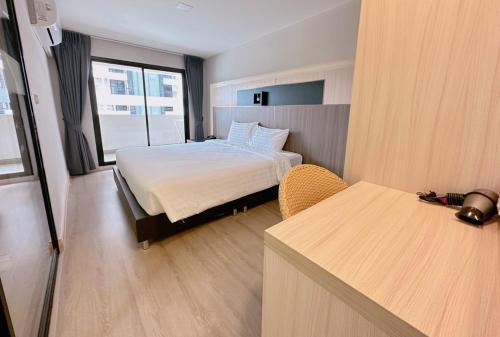 a hotel room with a bed and a window at โรงแรม โอทู แกรนด์ สุวรรณภูมิ แอร์พอร์ต in Bang Phli