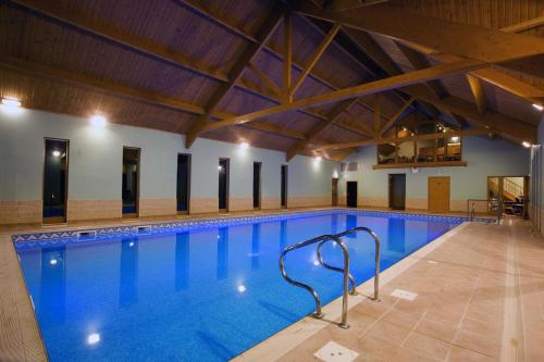 a large swimming pool with blue water at The Lake Country House Hotel & Spa in Llangammarch Wells