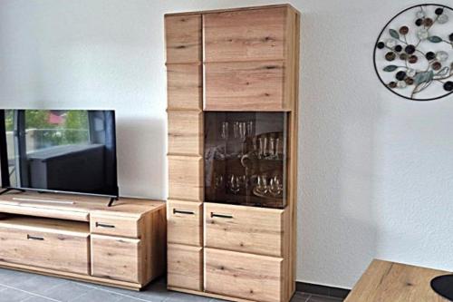 クックスハーフェンにあるLütte Koje 207 - Ferienwohnung 1 Zimmer Alteliebeの木製の大型エンターテイメントセンター(薄型テレビ付)