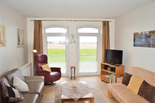 a living room with a couch and a tv at Seewind 5 in Cuxhaven