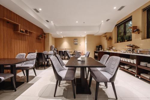 タシュケントにあるMonday Royal apart hotelのテーブルと椅子とカウンターのあるレストラン