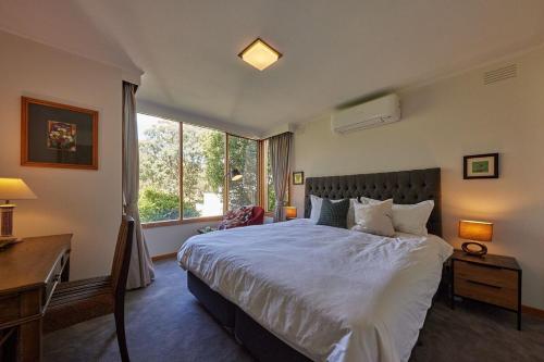 a bedroom with a bed and a desk and a window at Camellia Romance Retreat near Doncaster Westfield M3 in Doncaster
