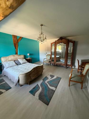 a bedroom with a bed and a chair and a mirror at Chez les Loulous in Chailly-sur-Armançon