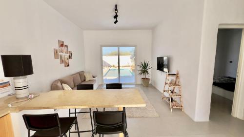 a living room with a table and some chairs at Mediterranean house in Djerba Midoun in Taguermess