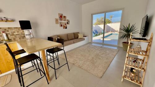 a living room with a table and chairs and a couch at Mediterranean house in Djerba Midoun in Taguermess