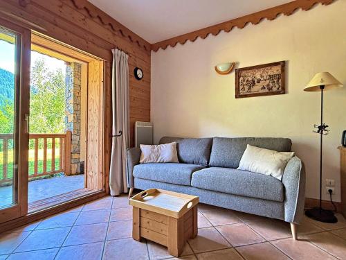 a living room with a couch and a balcony at Mouflon, terrasse confort piscine, Spa in Champagny-en-Vanoise
