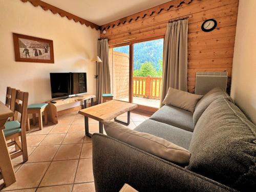 a living room with a couch and a table at Mouflon, terrasse confort piscine, Spa in Champagny-en-Vanoise