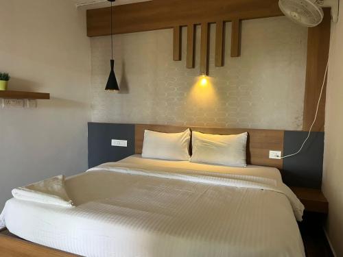 a bedroom with a large bed with white sheets at Wild root stay- Aster Chalet in Wayanad