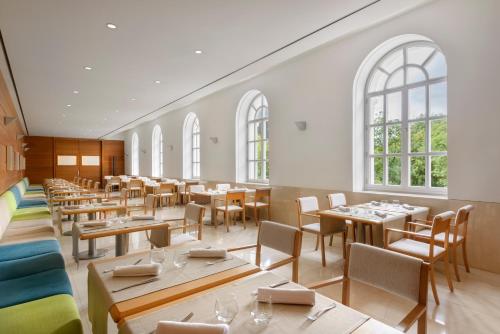 パンティコサにあるGran Hotel – Balneario de Panticosaのテーブルと椅子と窓のあるダイニングルーム