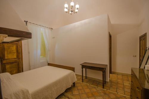 a bedroom with a bed and a table and a chandelier at Il Casino di Remartello in Loreto Aprutino