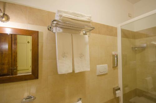 a bathroom with a shower and a mirror and towels at Il Casino di Remartello in Loreto Aprutino