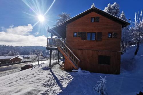une cabane en rondins dans la neige avec le soleil derrière elle dans l'établissement Chalet Les étoiles vue Mont Blanc, à Pugny-Chatenod