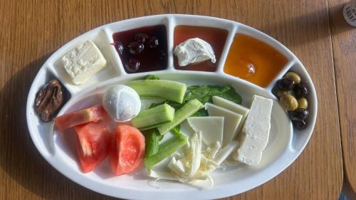 een bord kaas en groenten op een tafel bij Yeşilköy Bungalovs in Silifke