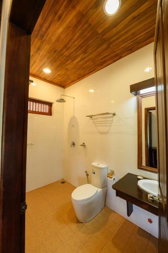 a bathroom with a toilet and a sink at Treasure Heritage Luang Prabang Hotel in Luang Prabang