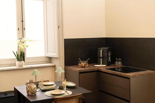 a kitchen with a counter and a table with a coffee maker at Silvia Home Suite in Palermo