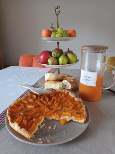 un tavolo con un piatto di cibo e un bicchiere di succo d'arancia di La Provende a Bard