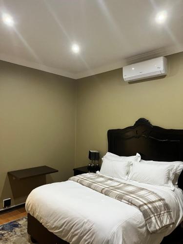 a bedroom with a large bed with white sheets at De Luna Apartments in Bethlehem