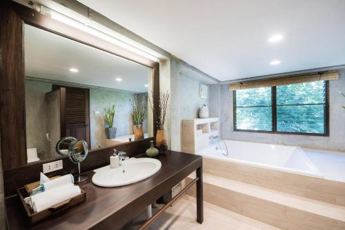 a bathroom with a large mirror and a tub and a sink at Cyngam Retreat- A private pool villa with service in Ban Pa Sao