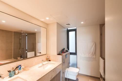 迪拜Private room in a luxury villa at Dubai hills的浴室里有洗手池、马桶和镜子。